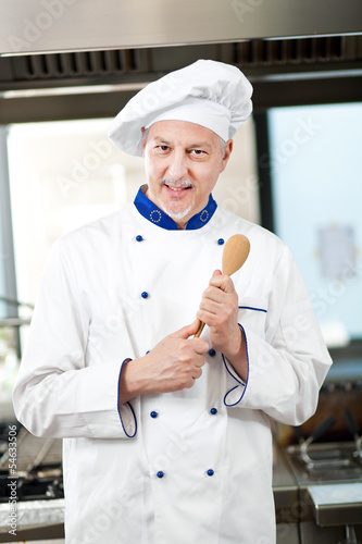 Photo: Friendly chef working in his kitchen Friendly chef working in his kitchen