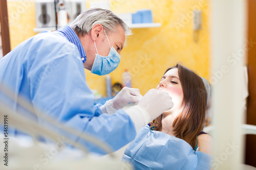 Photo: Dentist doing a treatment Dentist doing a treatment