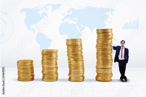 Photo: Businessman and gold coins growth chart Businessman and gold coins growth chart