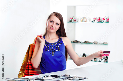 Photo: woman at shopping checkout paying credit card woman at shopping checkout paying credit card