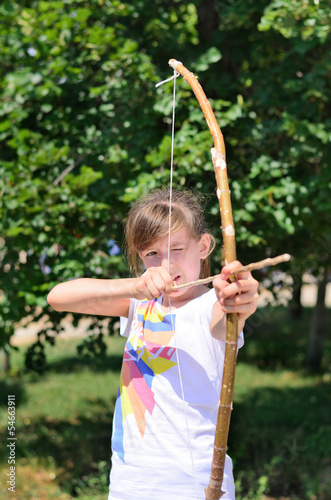 Photo: Young girl practising with a bow and arrow Young girl practising with a bow and arrow