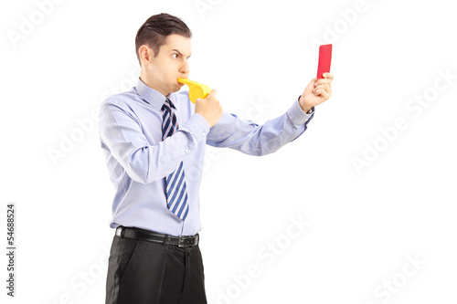 Photo: Young man blowing a whistle and showing a red card Young man blowing a whistle and showing a red card