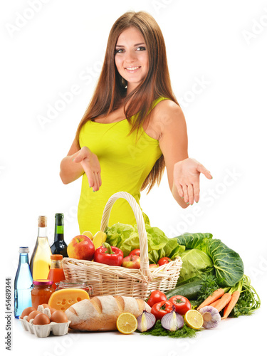 Photo: Young woman with assorted grocery products isolated on white Young woman with assorted grocery products isolated on white