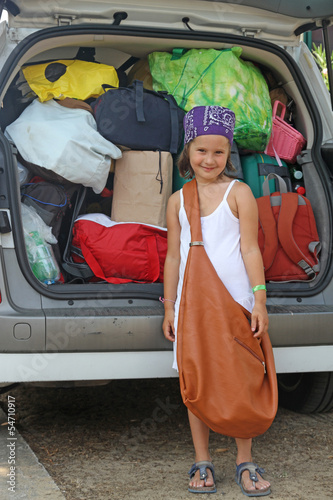 Photo: beautiful smiling girl with bag and suitcases in car beautiful smiling girl with bag and suitcases in car