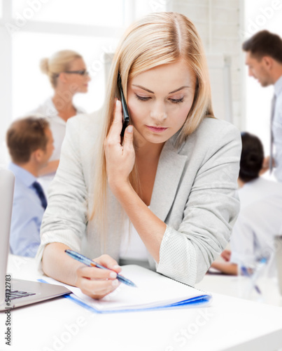 Photo: businesswoman with phone in office businesswoman with phone in office