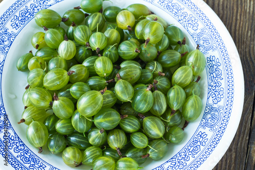 Photo: Green gooseberries on white plate Green gooseberries on white plate