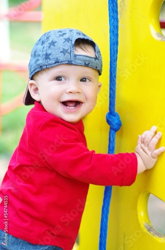 Photo: happy smiling baby boy on playground in summertime happy smiling baby boy on playground in summertime