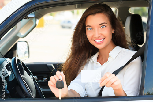 Photo: girl in a car showing a key and an empty white card girl in a car showing a key and an empty white card