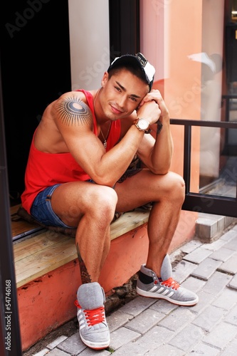 Photo: Stylish young man in shorts and cap Stylish young man in shorts and cap