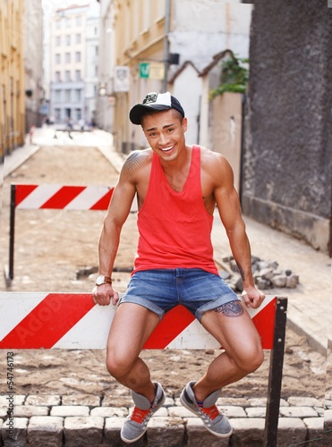Photo: Stylish young man in shorts and cap outdoors Stylish young man in shorts and cap outdoors