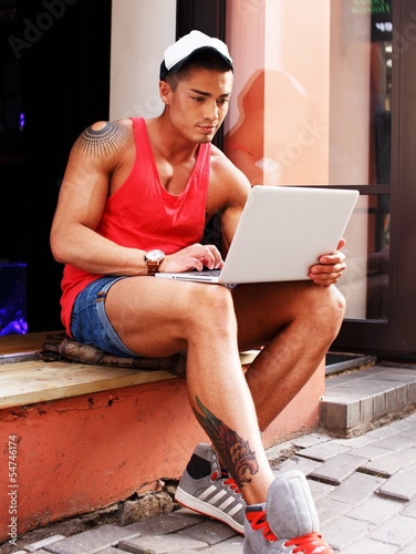 Photo: Stylish young man in shorts and cap Stylish young man in shorts and cap