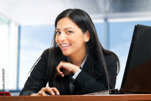 Photo: Smiling businesswoman at her desk Smiling businesswoman at her desk