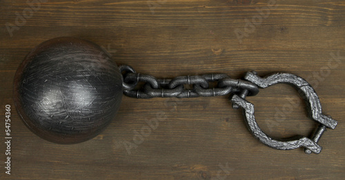 Photo: Ball and chain on wooden background Ball and chain on wooden background