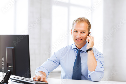 Photo: smiling businessman with smartphone in office smiling businessman with smartphone in office