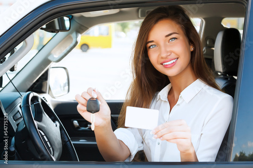 Photo: girl in a car showing a key and an empty white card girl in a car showing a key and an empty white card