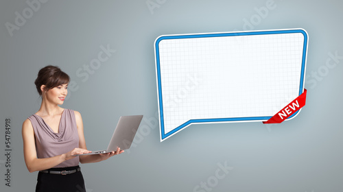 Photo: young woman holding a laptop and presenting modern speech bubble young woman holding a laptop and presenting modern speech bubble