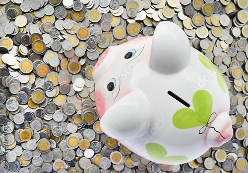 Photo: Pink piggy bank with many coins Pink piggy bank with many coins