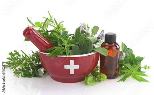 Photo: Mortar with medicine cross, fresh herbs and essential oil bottle Mortar with medicine cross, fresh herbs and essential oil bottle