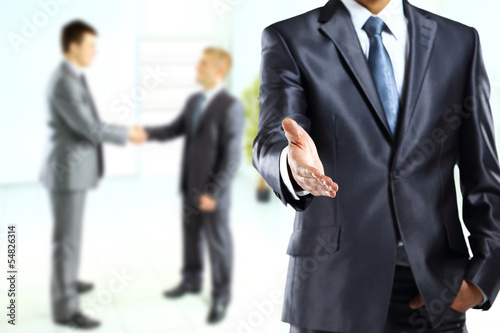 Photo: A business man with an open hand ready to seal a deal A business man with an open hand ready to seal a deal