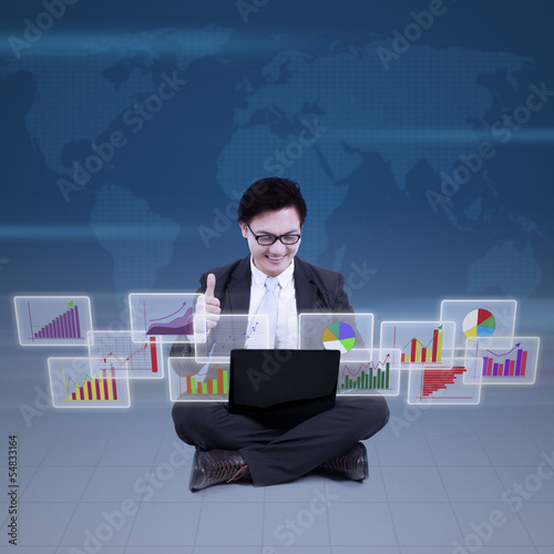 Photo: Businessman satisfied with finance reports online Businessman satisfied with finance reports online