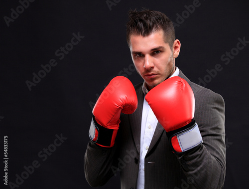 Photo: Business man ready to fight with boxing gloves Business man ready to fight with boxing gloves