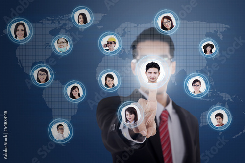 Photo: Futuristic touchscreen and businessman on blue Futuristic touchscreen and businessman on blue