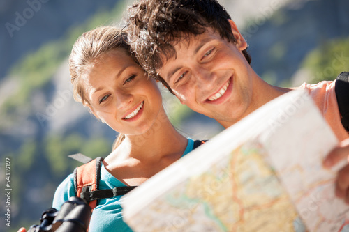 Photo: Closeup of couple in the mountains looking at the map Closeup of couple in the mountains looking at the map