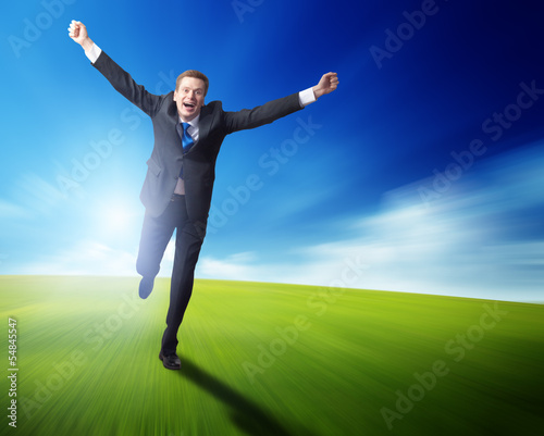 Photo: happy business man running on blured spring field happy business man running on blured spring field