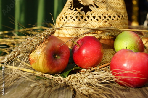 Photo: rural composition with apples, wheat and straw hat rural composition with apples, wheat and straw hat