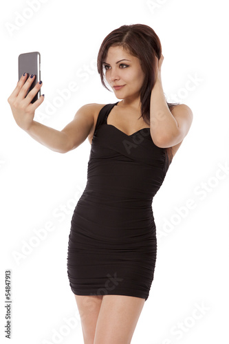 Photo: Young woman in a little black dress poses for a picture. Young woman in a little black dress poses for a picture.