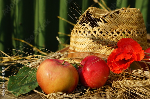 Photo: rural composition with apples, wheat and straw hat rural composition with apples, wheat and straw hat
