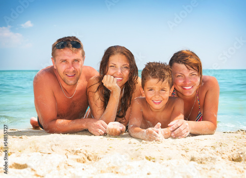 Photo: Happy Family Having Fun at the Beach. Summer Holidays Happy Family Having Fun at the Beach. Summer Holidays