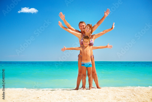 Photo: Happy Family Having Fun at the Beach. Vacation Happy Family Having Fun at the Beach. Vacation