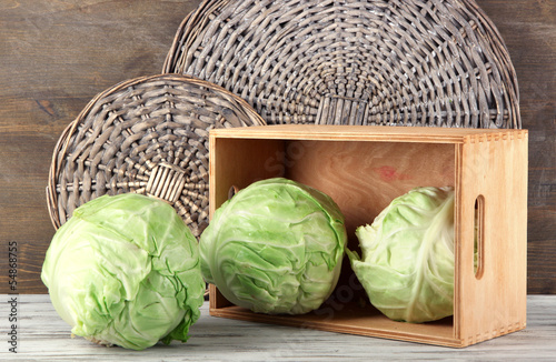Photo: Cabbage on table on wooden background Cabbage on table on wooden background