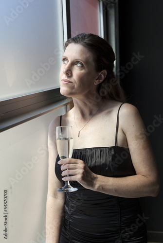 Photo: Middle Aged Woman in Black Dress with Champagne Middle Aged Woman in Black Dress with Champagne