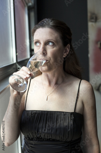 Photo: Middle Aged Woman in Black Dress with Champagne Middle Aged Woman in Black Dress with Champagne