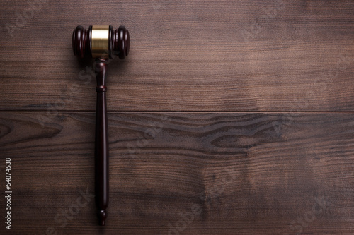 Photo: judge gavel on the brown wooden background judge gavel on the brown wooden background