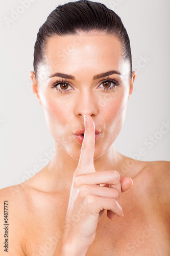 Photo: woman holding a finger in front of mouth as a sign of silence woman holding a finger in front of mouth as a sign of silence
