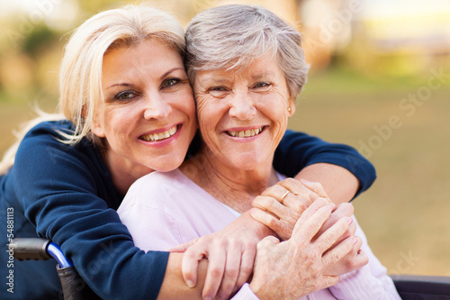 Photo: middle aged woman embracing disabled senior mother middle aged woman embracing disabled senior mother