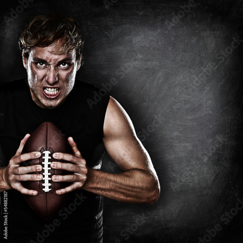 Photo: Football player portrait holding american football Football player portrait holding american football