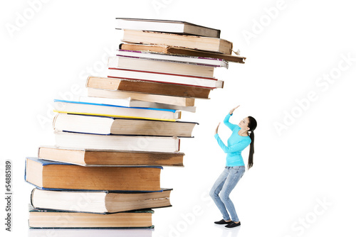 Photo: Student woman afraid of pile of books. Student woman afraid of pile of books.