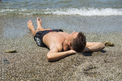 Photo: one man sunbathing one man sunbathing
