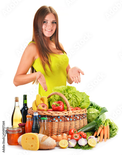 Photo: Young woman with assorted grocery products isolated on white Young woman with assorted grocery products isolated on white