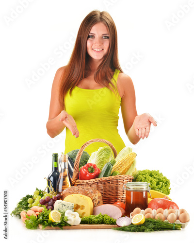 Photo: Young woman with assorted grocery products isolated on white Young woman with assorted grocery products isolated on white