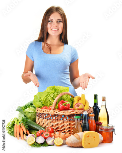 Photo: Young woman with assorted grocery products isolated on white Young woman with assorted grocery products isolated on white