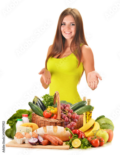 Photo: Young woman with assorted grocery products isolated on white Young woman with assorted grocery products isolated on white