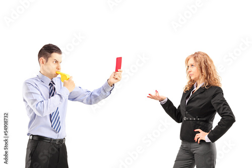 Photo: Young businessman blowing a wistle and showing a red card Young businessman blowing a wistle and showing a red card
