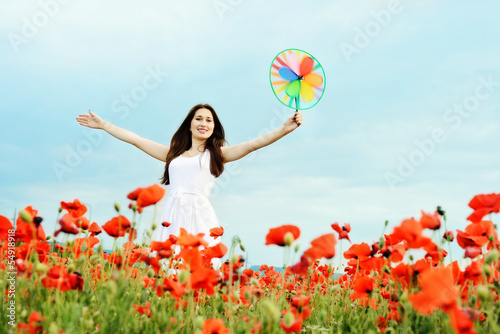 Photo: happy girl with windmill in field happy girl with windmill in field