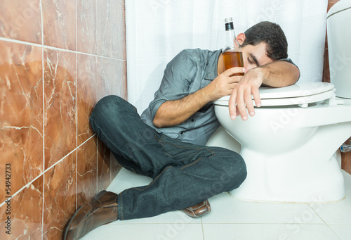Photo: Drunk hispanic man sleeping over the toilet bowl Drunk hispanic man sleeping over the toilet bowl