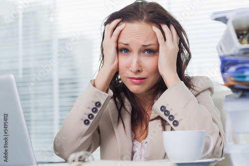 Photo: Desperate businesswoman touching her forehead Desperate businesswoman touching her forehead